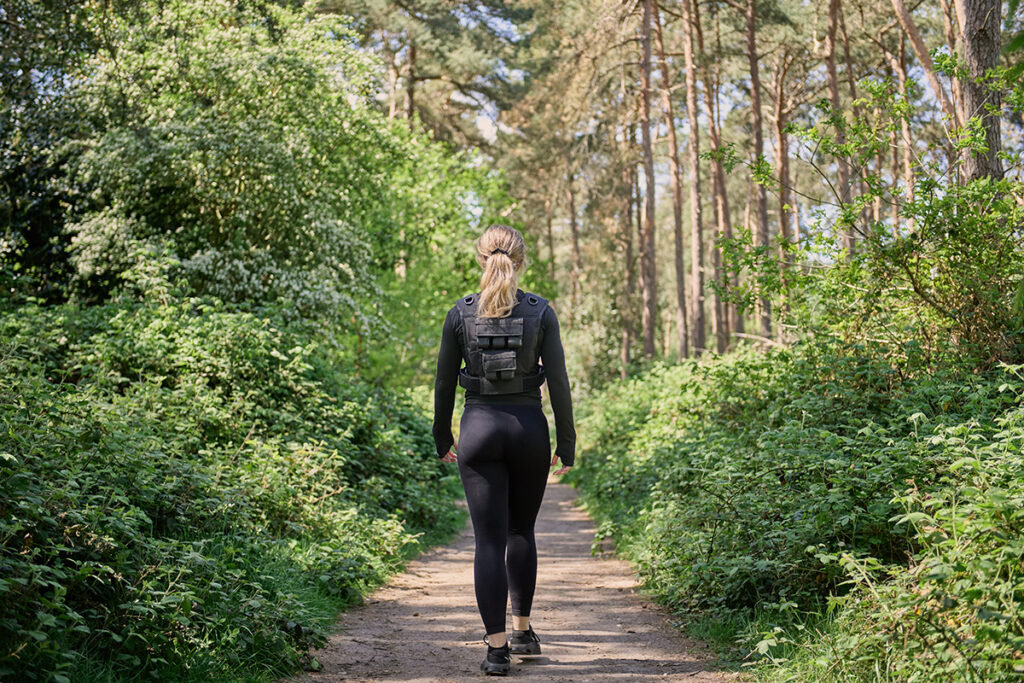 Mirafit Gen II Adjustable Weight Vest woman walking in the forest wearing a Mirafit Gen II Adjustable Weight Vest