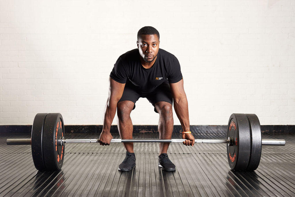 Standard deadlift Man performing a deadlift using a Mirafit Olympic barbell and Mirafit Crumb Rubber Olympic Bumper Plates