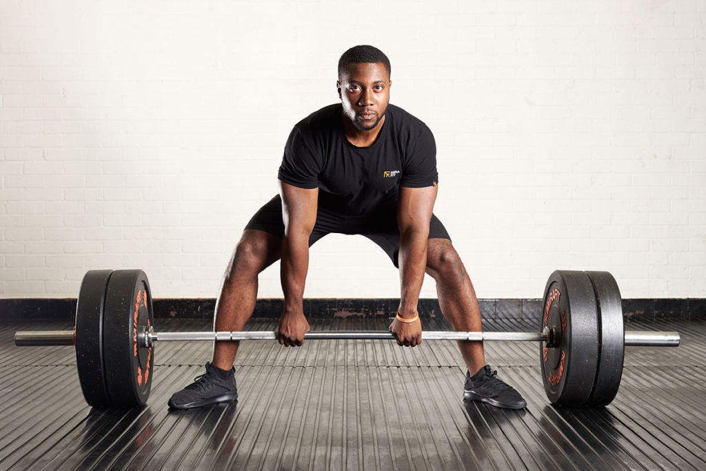 Sumo deadlift Man using a Sumo deadlift using a Mirafit Olympic barbell and Mirafit Crumb Rubber Olympic Bumper Plates