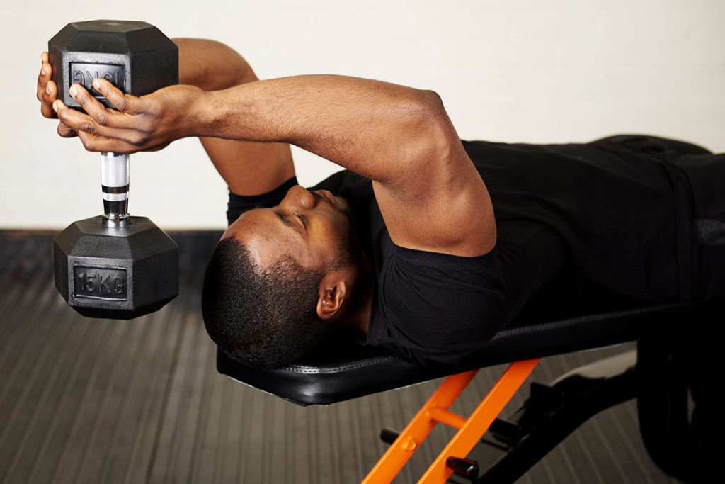 Man doing a skull crusher with a 15kg dumbbell