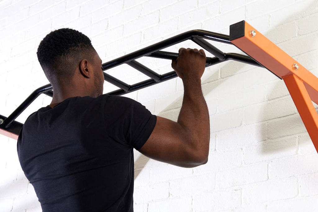 Man doing a pull up on a Mirafit Multi Grip Wall Mounted Pull Up Bar