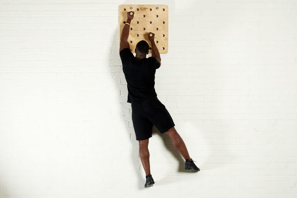 Vertical climb fitness expert uses a Mirafit Climbing Peg Board to climb vertically