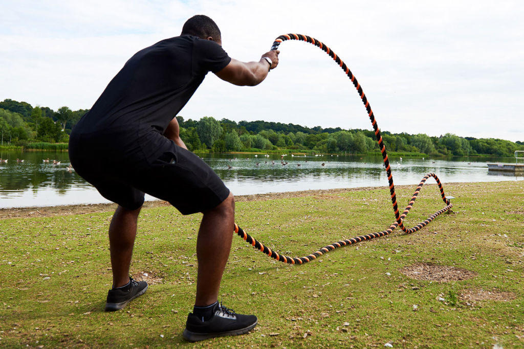 fitness expert performs alternating waves using mirafit battle ropes