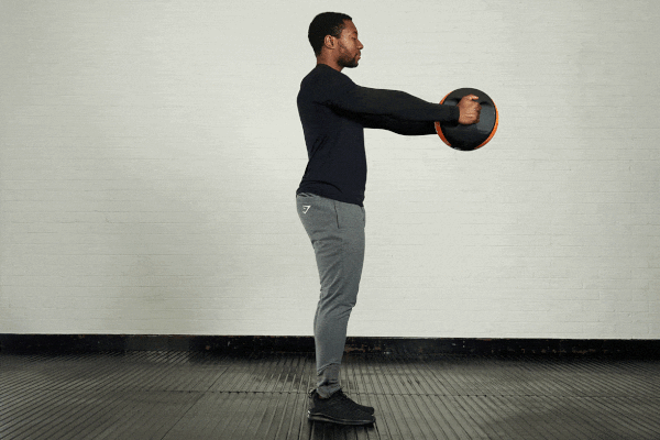 Reaching Romanian deadlift Man demonstrating the reaching Romanian deadlift exercise with a Mirafit double handle medicine ball