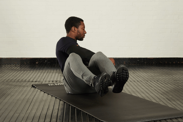 Russian twist Man demonstrating the Russian twist exercise with a Mirafit double handle medicine ball