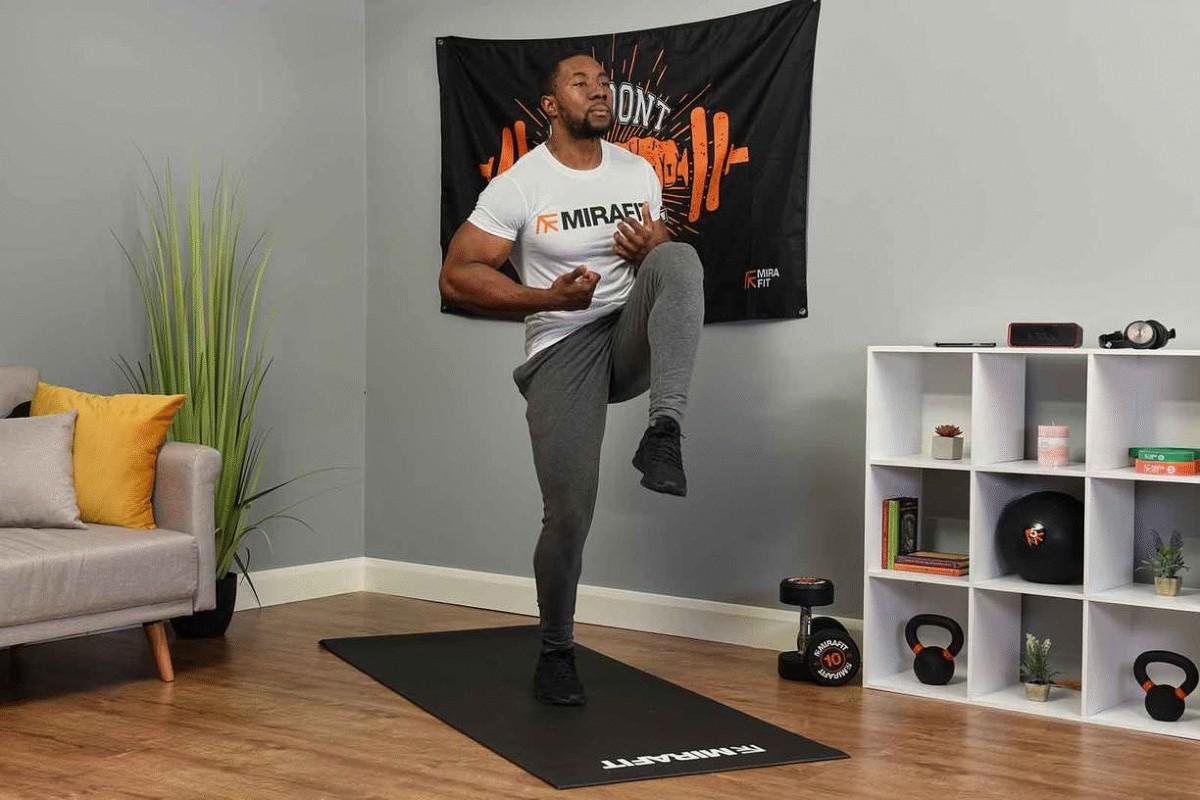 This is an image of a fitness model demonstrating the high knees exercise at home as part of a high intensity interval training work out. 
