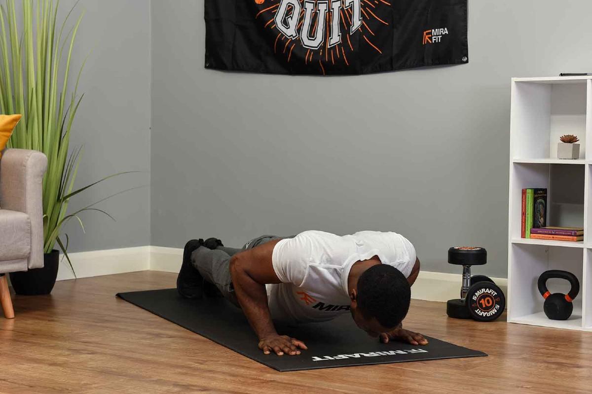 This is an image of a fitness model demonstrating the push-up exercise at home. 