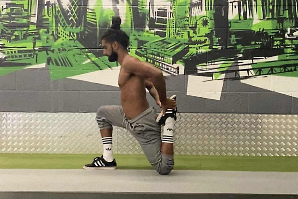 Calisthenics expert Riki Warren performing a quad stretch