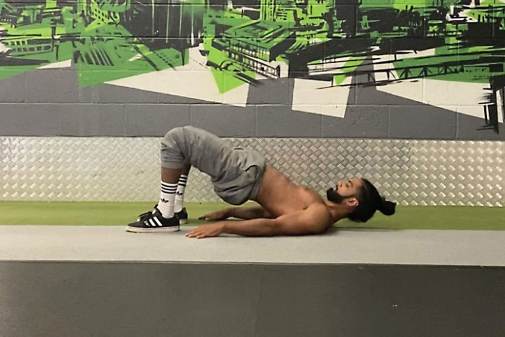 Calisthenics expert Riki Warren performing a glute bridge