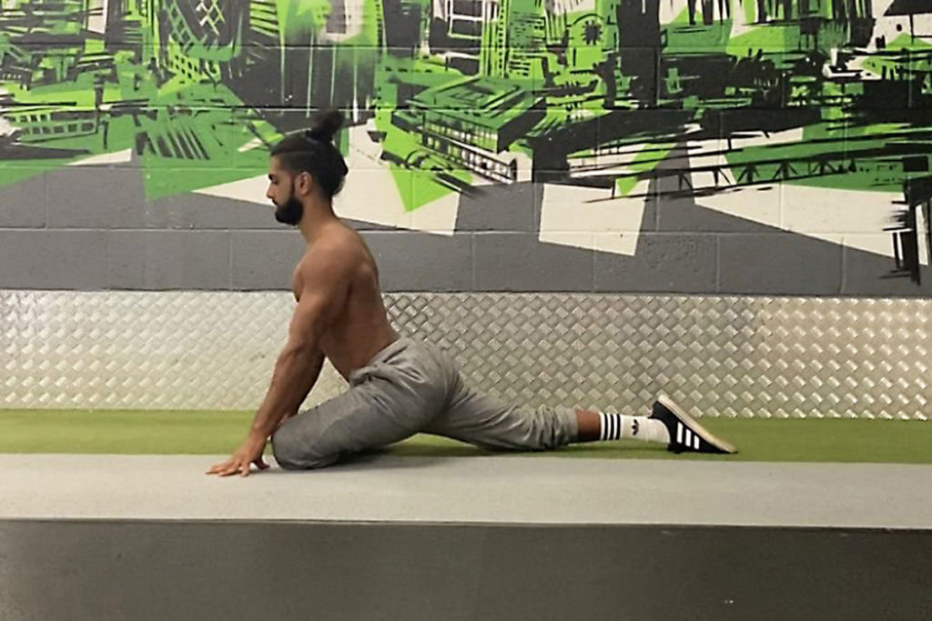Calisthenics expert Riki Warren performing a pigeon stretch